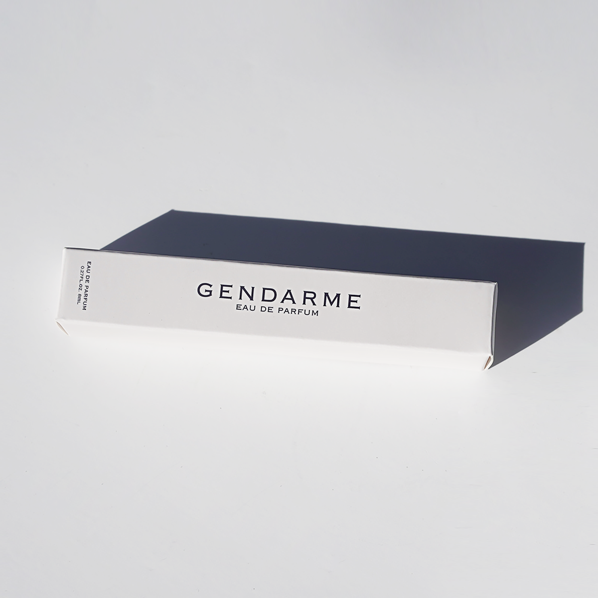 A decorative image of travel spray bottle of Gendarme Eau De Parfum with a navy blue and white label, presented against a neutral background.