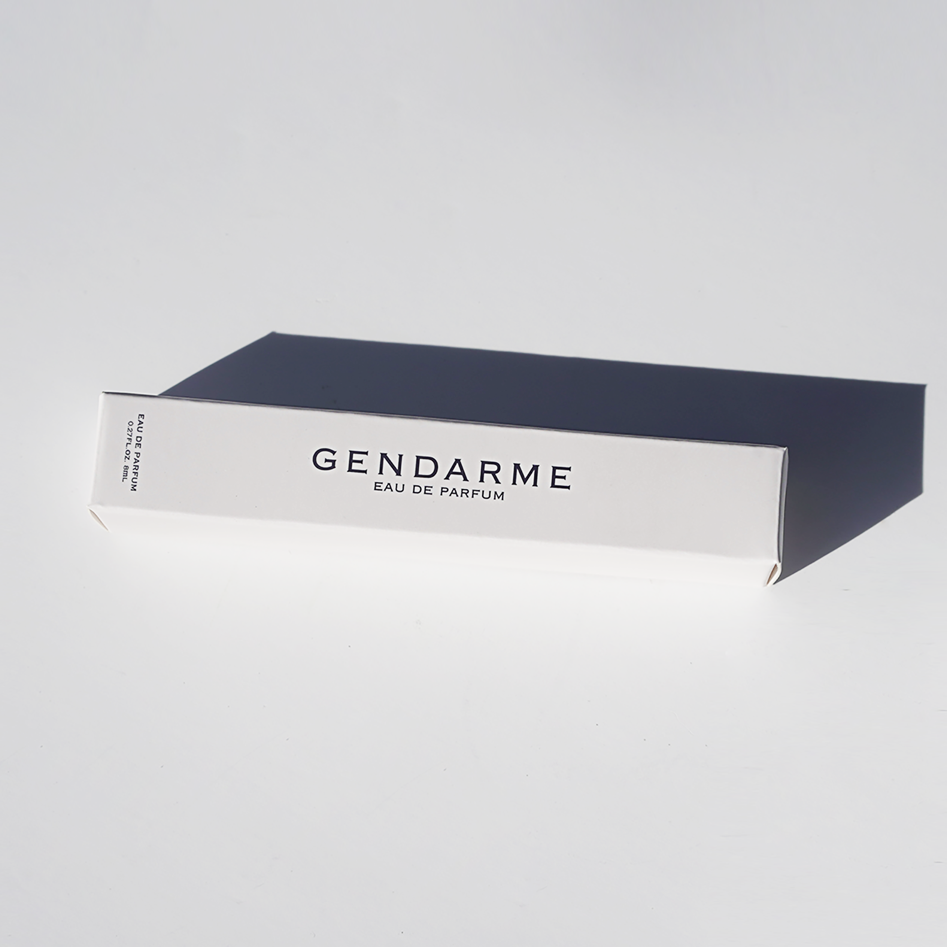 A decorative image of travel spray bottle of Gendarme Eau De Parfum with a navy blue and white label, presented against a neutral background.