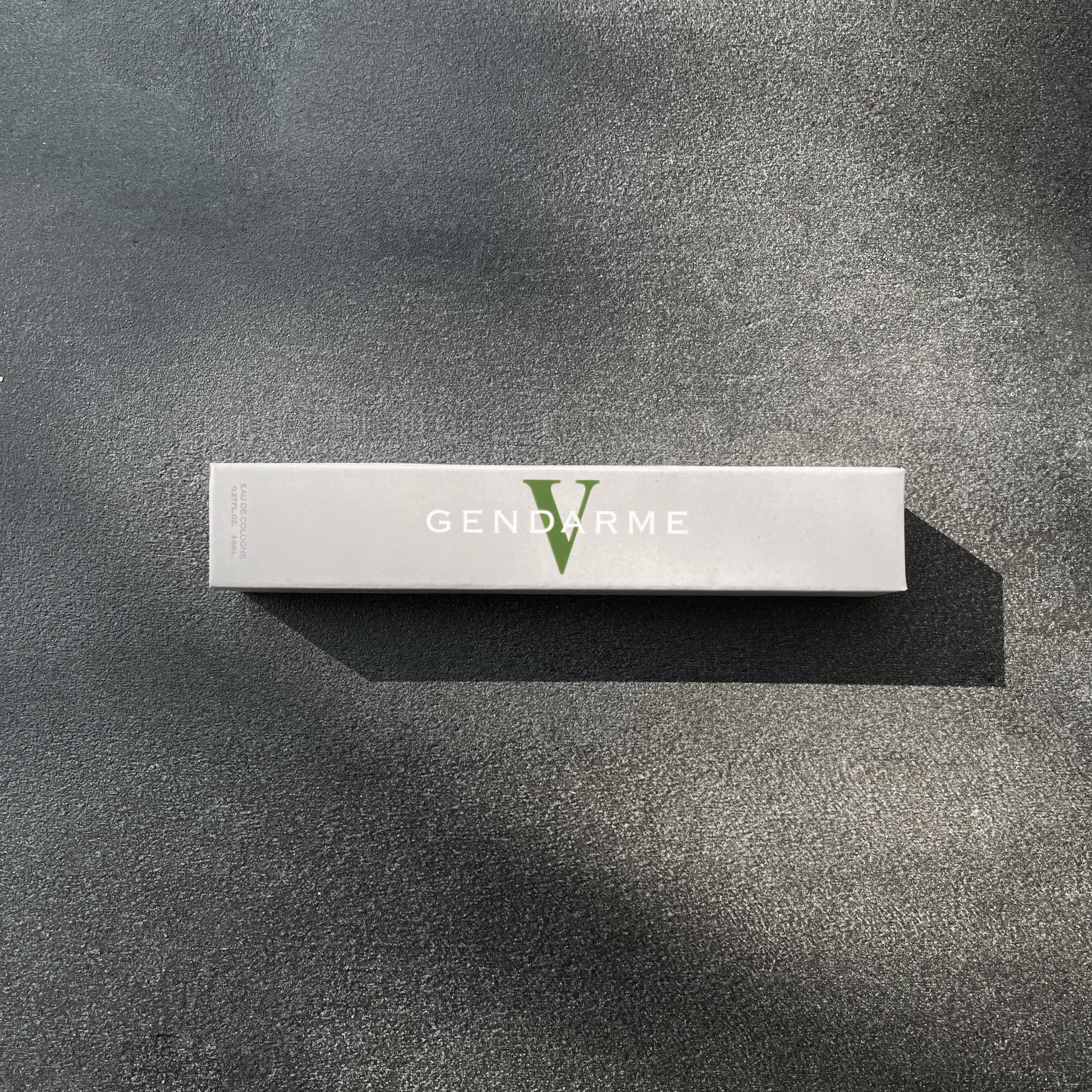 Decorative Image of Grey box on granite background. Box includes logo in white and green "Gendarme V'